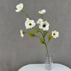 Nahaufnahme des künstlichen weißen Anemonen-Blumenzweigs in einer dekorativen Glasvase.