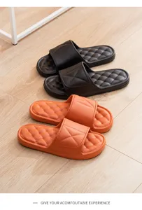 Detailed view of thick-soled cushioned slippers in black and orange, anti-slip design.