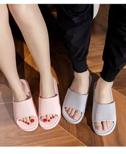 Detailed shot of couple EVA slippers featuring anti-slip striped design for home bathroom use.