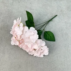 Close-up view of the artificial pink hydrangea flower stem showing delicate petals and green leaves.