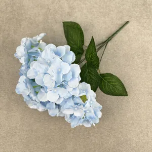 Close-up detail of artificial blue hydrangea flower branch with realistic green leaves.