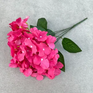 Close-up view of artificial pink hydrangea flower bouquet with green leaves and stems.