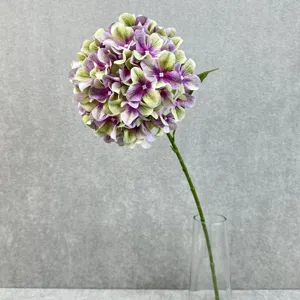 Close-up detail of artificial hydrangea flower head in a clear glass vase for decor.