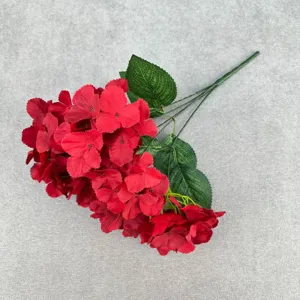 Red artificial hydrangea detail shot showing 5-fork large petals and realistic green leaves.