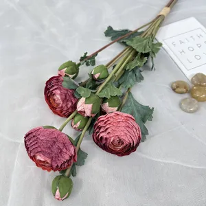 Détail de bouquet de renoncules artificielles avec pétales feuilles et bourgeons réalistes.