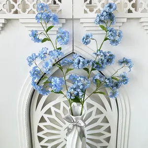 Artificial blue flowers in white vase home decor faux floral arrangement for room decoration.