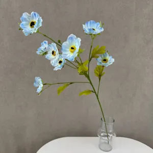 Nahaufnahme eines künstlichen blauen Anemonenblütenzweigs in klarer Glasvase Dekor.