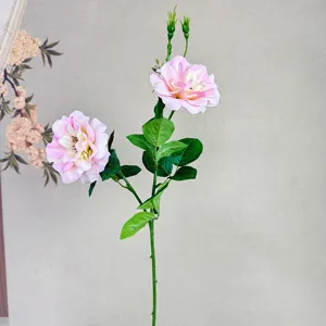 Detailaufnahme eines künstlichen rosa Rosenzweiges mit zwei Blütenköpfen für die Dekoration.