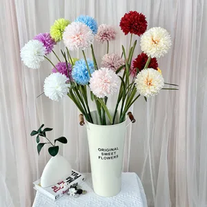 Detailed view of colorful artificial snowball flowers in a white bucket for home decor.