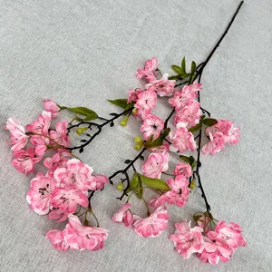 Détail en gros plan d'une branche de fleurs de cerisier artificielles roses pour décoration maison.