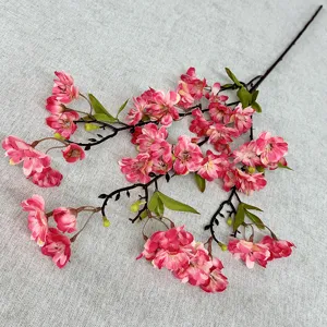 Gros plan détaillé d'une branche de cerisier artificiel, fleurs de soie roses.