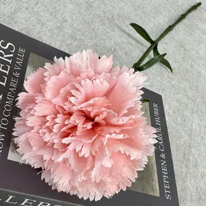 Close-up detail of artificial pink carnation flower with green stem, photography prop.