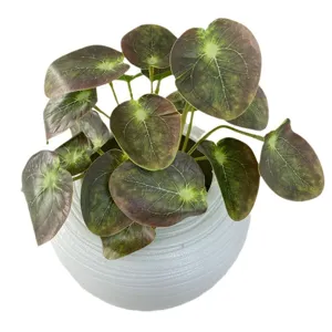 Artificial potted plant with realistic leaves in white ceramic pot for home indoor decor.
