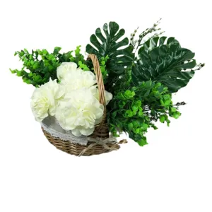 Composition florale artificielle en panier en osier avec feuilles de monstera pour deco.