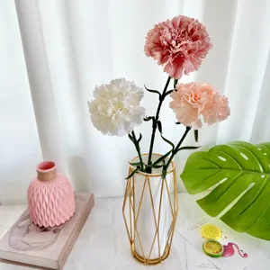 Arrangement de fleurs d'œillets artificiels avec vase en fil d'or pour la décoration.