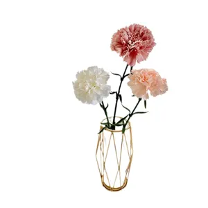 Arrangement de fleurs d'œillets artificiels dans un vase doré géométrique pour maison