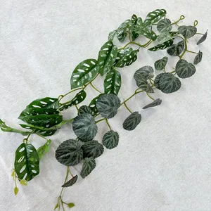 Artificial plant vine detail view, realistic green monstera leaves for home wall decoration.
