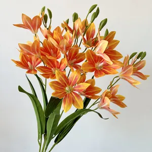 Dettaglio del bouquet di fiori artificiali di magnolia con petali arancioni vivaci e foglie verdi.
