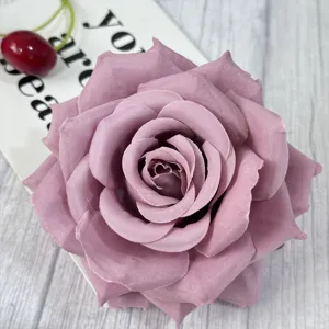 Close-up detail shot of a purple artificial rose flower head with full petals and realistic texture.