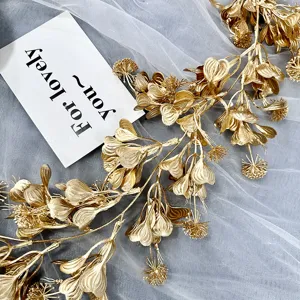 Detalle de vid de flores artificiales doradas, elemento floral para bodas exquisito.