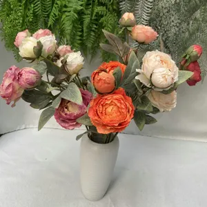 Detailansicht künstlicher Pfingstrosen, bunter Seidenblumenstrauß in grauer Keramikvase.