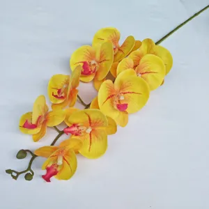 Artificial orchid flower detail, realistic yellow petals with red center for decor.