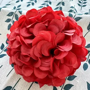 Red artificial flower ball detail shot, silk floral head for wedding table decor and DIY crafts.