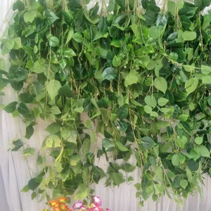 Artificial green plant hanging vine detail, realistic leaves for wedding and home wall decor.