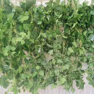 Close-up detail of artificial hanging ivy vines, dense green leaves for wall decor.