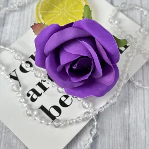 Purple artificial rose flower head detail, brushed fabric material for wedding and event decor.
