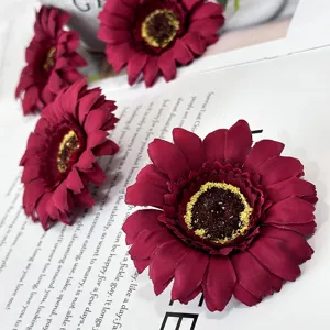 Artificial chrysanthemum flower close-up, deep red gerbera petals with yellow center detail.