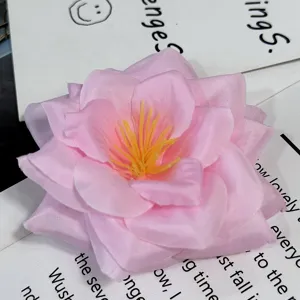 Vista detallada en primer plano de una flor de tela artificial rosa con estambres amarillos.