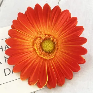 Primo piano di un fiore di gerbera artificiale arancione per decorazione tavola e ghirlande.