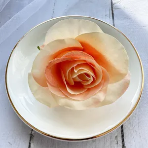 Artificial peach rose flower head detail, fabric floral decor for wedding table, DIY craft accessory.