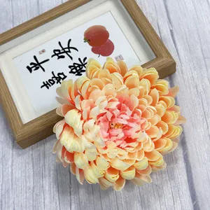 Artificial chrysanthemum flower head, peach yellow gradient fabric floral decor detail.