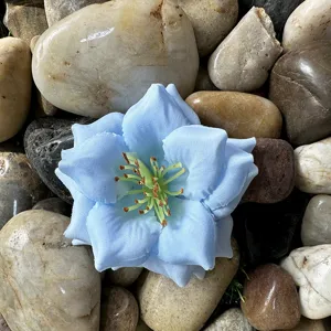 Gros plan détaillé de la fleur artificielle en tissu bleu clair, idéale pour le bricolage.