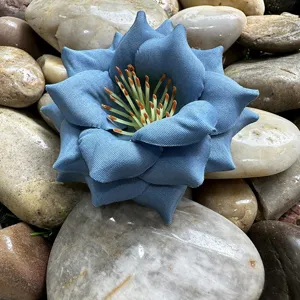 Gros plan détaillé d'une fleur artificielle en tissu bleu avec des étamines pour le bricolage.