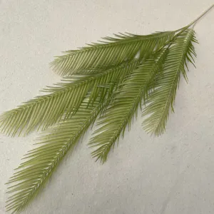 Artificial cycad leaf simulation green plant branch indoor home decor accessory close up detail view.