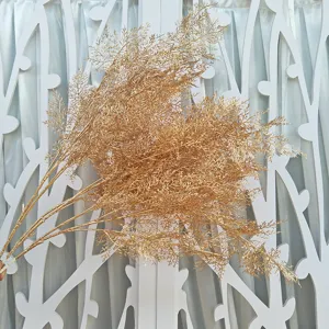 Artificial gold frost grass branch detail for wedding background decoration display.