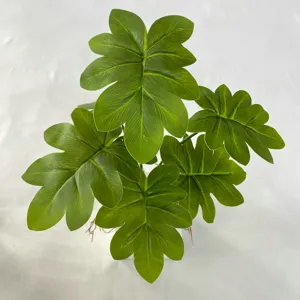 Detail view of artificial green plant leaves, realistic texture for interior home decor.