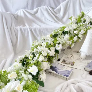 Ghirlanda di fiori artificiali bianchi e verdi per arco nuziale, sfondo floreale finto.