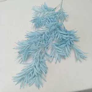 Detailed view of artificial blue bamboo leaf branch, plastic plant for floral decor