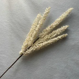 Gros plan détaillé d'une branche de baies artificielles blanches pour arrangement floral.