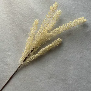 Gros plan sur l'épi de millet artificiel, branche florale blanche réaliste pour décor d'intérieur.