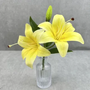 Détail de fleurs de lys jaunes artificielles, arrangement floral 3D réaliste dans un vase en verre.