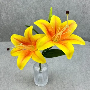 Gros plan de fleurs de lis jaunes artificielles dans un vase en verre clair pour déco détail.