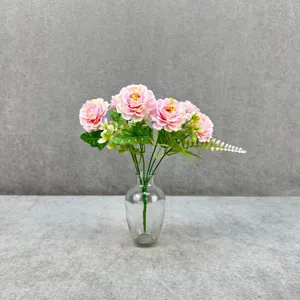 Detail view of pink artificial peony flower bouquet in a clear glass vase for home decor setup.