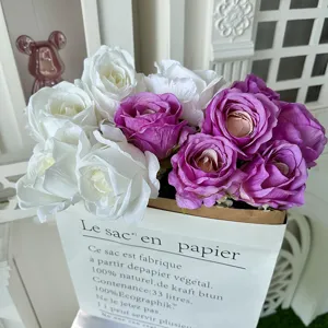 Detailed view of artificial white and purple roses arrangement in a chic paper bag, perfect decor.