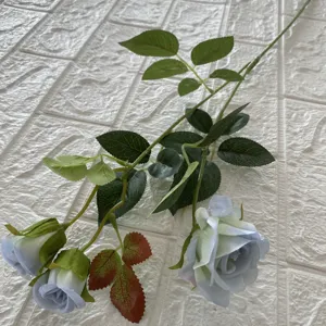 Vista dettagliata di un singolo ramo di rosa artificiale con tre teste e foglie verdi.