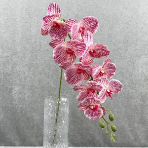 Gedetailleerd overzicht van kunstmatige roze gestreepte orchidee in glazen vaas voor thuis.